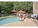 A luxurious pool area featuring lounge chairs, umbrellas, and a well-maintained brick patio at 6317 Benbrooke Overlook Nw, Acworth, GA 30101