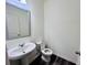 Half bathroom featuring a white pedestal sink, silver framed mirror and dark wood-look flooring at 7775 Sudbury Cir, Covington, GA 30014