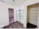 Bright bathroom features wood-look floors, glass shower, and a closet with shelving at 7775 Sudbury Cir, Covington, GA 30014