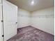 Walk-in closet with wall-mounted shelving and plush, patterned carpeting at 7775 Sudbury Cir, Covington, GA 30014