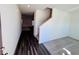 Inviting entryway features hardwood floors, staircase, and a glimpse into the carpeted living area at 7775 Sudbury Cir, Covington, GA 30014
