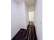 Hallway features dark wood flooring and a view into the half bathroom with white toilet and sink at 7775 Sudbury Cir, Covington, GA 30014