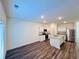 Well-lit kitchen featuring white cabinets, stainless steel appliances, an island, and hardwood floors at 7775 Sudbury Cir, Covington, GA 30014