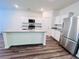 Modern kitchen boasts a center island, granite countertops, stainless appliances, and ample storage space at 7775 Sudbury Cir, Covington, GA 30014