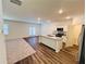 Open concept kitchen with an island, white cabinets, stainless steel appliances, and hardwood floors at 7775 Sudbury Cir, Covington, GA 30014