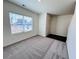 Cozy carpeted room with a window, door and hardwood flooring, offering a versatile space at 7775 Sudbury Cir, Covington, GA 30014