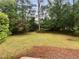 Large grassy backyard surrounded by lush green trees offers a serene and private outdoor space at 2060 Devore Sw Dr, Marietta, GA 30008