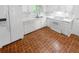 Bright kitchen featuring all white appliances, white cabinetry, and a brick paver style flooring at 2060 Devore Sw Dr, Marietta, GA 30008