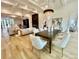 Open-concept dining room featuring a modern chandelier, hardwood floors, and a connecting living space at 2837 Darlington Run, Duluth, GA 30097