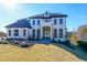 Stunning two-story white home with a manicured lawn and black framed windows at 2837 Darlington Run, Duluth, GA 30097