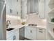 Galley kitchen with white cabinets, granite countertops, stainless steel appliances, and modern fixtures at 2837 Darlington Run, Duluth, GA 30097