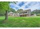 Expansive backyard featuring lush green lawn, mature trees, and a gentle slope enhancing its natural appeal at 4826 Dean Sw Ln, Lilburn, GA 30047