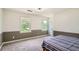 Spacious bedroom features a neutral palette with a chair rail accent, carpet, and two windows bringing in natural light at 4826 Dean Sw Ln, Lilburn, GA 30047