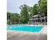 Large community pool with multiple stories of covered seating areas and surrounded by mature trees at 4826 Dean Sw Ln, Lilburn, GA 30047