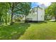Spacious backyard with a grass lawn and a wooden deck attached to the home at 5250 Forest Downs Ln, Atlanta, GA 30349