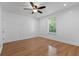 Bright bedroom with hardwood floors, a ceiling fan, and a large window with natural light at 5250 Forest Downs Ln, Atlanta, GA 30349