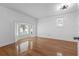 Bright bedroom featuring hardwood floors, natural light from a bay window and a modern ceiling light fixture at 5250 Forest Downs Ln, Atlanta, GA 30349