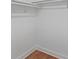 Walk in closet with installed storage and hardwood floors at 5250 Forest Downs Ln, Atlanta, GA 30349