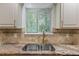 Close-up on granite countertops, a gold faucet and tile backsplash at 5250 Forest Downs Ln, Atlanta, GA 30349