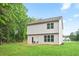 Backyard featuring a grassy yard, two-story siding, and a small deck with chairs at 130 Bingley Ct, Covington, GA 30016