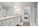This primary bathroom features double sinks, modern fixtures, and a view into the primary bedroom at 130 Bingley Ct, Covington, GA 30016