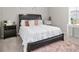 A charming bedroom is furnished with a bed, nightstand, and is decorated with neutral-colored accessories at 130 Bingley Ct, Covington, GA 30016