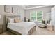 This cozy bedroom features a queen bed, neutral colors, and large windows overlooking lush greenery at 130 Bingley Ct, Covington, GA 30016