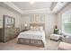 This bedroom boasts tray ceilings, a queen bed, and ample natural light from a nearby window at 130 Bingley Ct, Covington, GA 30016