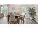 Bright dining room features a wood table, seating for four, a large window, and a decorative palm at 130 Bingley Ct, Covington, GA 30016