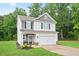 Charming two-story home features a two-car garage and a well manicured lawn at 130 Bingley Ct, Covington, GA 30016