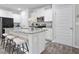 Bright kitchen features white cabinets, stainless steel appliances, and a granite countertop island with seating at 130 Bingley Ct, Covington, GA 30016