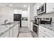 Well-lit kitchen features stainless steel appliances, granite countertops, and white cabinets for a modern look at 130 Bingley Ct, Covington, GA 30016