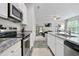 Open kitchen with stainless steel appliances, granite countertops, and views into a living room with lots of light at 130 Bingley Ct, Covington, GA 30016