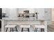 Elegant kitchen island features granite countertops and barstool seating at 130 Bingley Ct, Covington, GA 30016