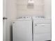 This laundry room is equipped with a washer and dryer with overhead shelving for storage at 130 Bingley Ct, Covington, GA 30016
