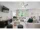 Spacious living room featuring modern sectional sofa, TV, and ceiling fan at 130 Bingley Ct, Covington, GA 30016