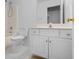 Bathroom featuring white cabinets and tile and shower/tub combo with neutral colored walls at 30 Stonewall Dr, Covington, GA 30016