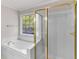 Bright bathroom featuring a tub and a gold trimmed shower enclosure at 30 Stonewall Dr, Covington, GA 30016
