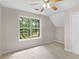 Bedroom featuring a ceiling fan, neutral walls and carpet, and a large window with a treed view at 30 Stonewall Dr, Covington, GA 30016