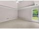Relaxing bedroom showcasing plush carpeting, a tray ceiling, and a large window at 30 Stonewall Dr, Covington, GA 30016