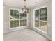 Bright dining area with large windows, crown molding, and modern light fixture at 30 Stonewall Dr, Covington, GA 30016
