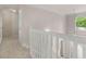 Upstairs hallway with white banister, arched window with pendant lamp, and visible staircase below at 30 Stonewall Dr, Covington, GA 30016