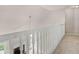 Carpeted upstairs hallway showcasing a white banister with view into the living room below at 30 Stonewall Dr, Covington, GA 30016