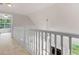 Upstairs hallway with a white railing offering a view of the foyer and living room below at 30 Stonewall Dr, Covington, GA 30016