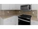 Bright kitchen featuring granite countertops, stainless steel microwave, and white cabinets at 30 Stonewall Dr, Covington, GA 30016