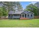 Large backyard featuring a wood deck, screened porch, mature trees, and privacy fence at 325 N Oakland Cir, Mcdonough, GA 30253