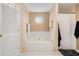 Bathroom with a white tiled tub and a separate shower with black and white accessories at 325 N Oakland Cir, Mcdonough, GA 30253