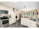 Kitchen with stainless steel appliances, white cabinetry, and view of dining area at 325 N Oakland Cir, Mcdonough, GA 30253