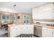 Bright kitchen with white cabinets, stainless steel appliances, and a view of the dining area at 325 N Oakland Cir, Mcdonough, GA 30253
