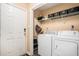 Functional laundry room equipped with washer, dryer, and shelving at 325 N Oakland Cir, Mcdonough, GA 30253